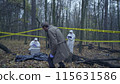Police detective crossing yellow tape to examine a deceased person, crime investigation 115631586