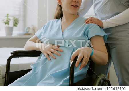 Pregnant patient caressing her belly and smile gently while nurse comforting her Pregnant patient caressing her belly and smile gently while nurse comforting her 115632101