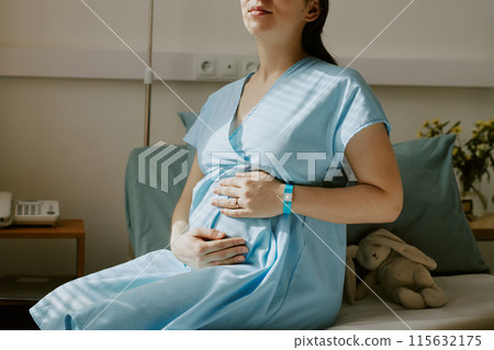 Young pregnant mother expecting her labor and caressing her belly Young pregnant mother expecting her labor and caressing her belly 115632175