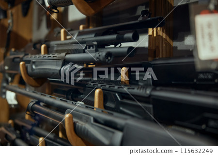 Gun machine and rifle assortment on rack at weapon store Gun machine and rifle assortment on rack at weapon store 115632249