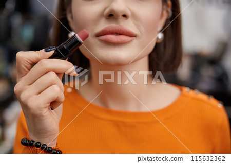 Woman testing matt lipstick, her face close up Woman testing matt lipstick, her face close up 115632362