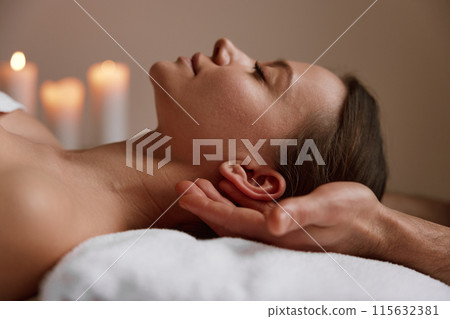 Peaceful female face at massage session in spa center 115632381
