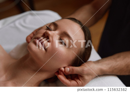 Closeup peaceful female face at massage session in spa center 115632382