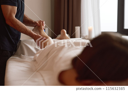 Woman client suffering from cramps enjoying legs sports massage therapy 115632385