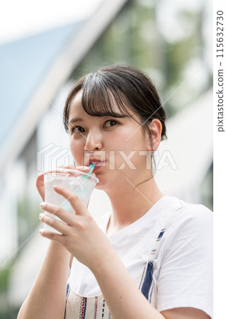 Young and cute Japanese woman drinking water outdoors | Heat stroke prevention | Hydration 115632730