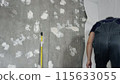 A man glues wallpaper on the floor in a room, Time lapse 115633055