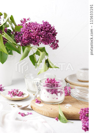 Preparation of syrup from the flowers of lilac in glass jar with sugar. White background. Selective focus. vertical copy space 115633191