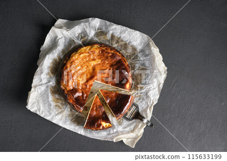 Top view of basque burnt cheesecake liced on black table. copy space 115633199