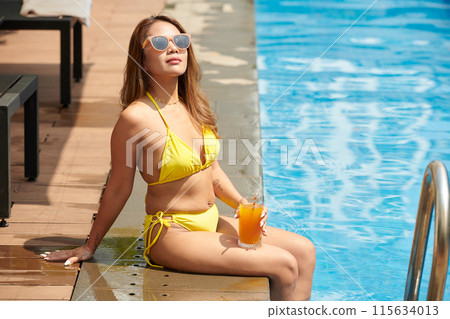 Woman in Bikini Sitting on Pool Edge 115634013