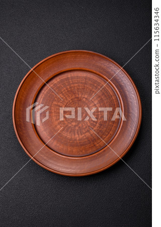 Empty ceramic round plate on dark textured concrete background 115634346