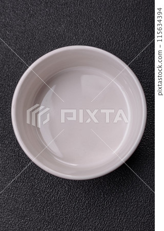 Beautiful empty white ceramic gravy boat on a concrete background 115634394