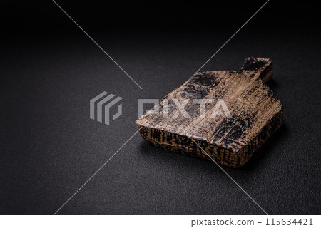 Empty wooden cutting board on dark textured concrete background Empty wooden cutting board on dark textured concrete background 115634421