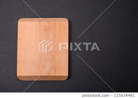 Empty wooden cutting board on dark textured concrete background Empty wooden cutting board on dark textured concrete background 115634461