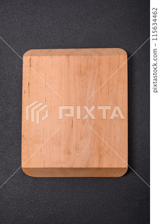 Empty wooden cutting board on dark textured concrete background Empty wooden cutting board on dark textured concrete background 115634462