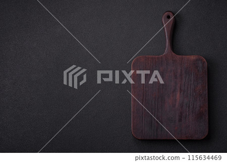 Empty wooden cutting board on dark textured concrete background Empty wooden cutting board on dark textured concrete background 115634469
