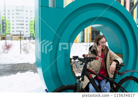 Woman Sitting on Bench Talking on Cell Phone Woman Sitting on Bench Talking on Cell Phone 115634817