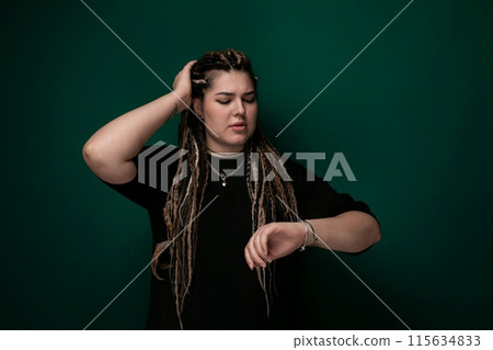 Woman With Dreadlocks Standing in Front of Green Wall Woman With Dreadlocks Standing in Front of Green Wall 115634833