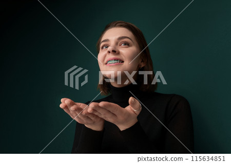 Woman Standing in Front of Green Wall Woman Standing in Front of Green Wall 115634851