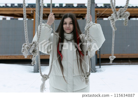 Woman Standing on Swing in Snow Woman Standing on Swing in Snow 115634887
