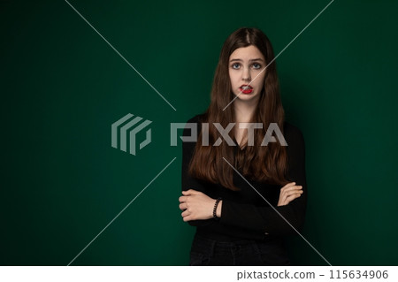 Woman With Arms Crossed Against Green Background Woman With Arms Crossed Against Green Background 115634906