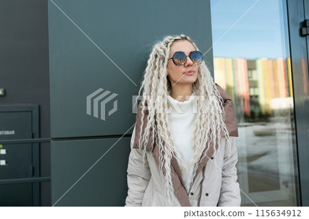 Woman With White Dreadlocks Standing in Front of a Building Woman With White Dreadlocks Standing in Front of a Building 115634912