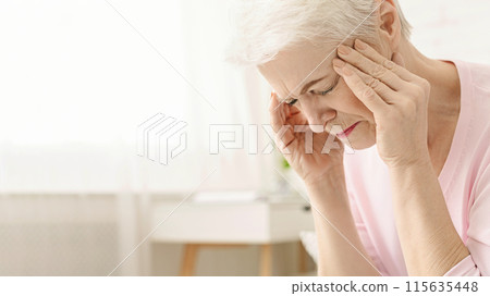 Senior woman having headache and touching her temples, suffering from migraine, free space 115635448