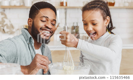 Cheerful Black Dad Teaching Lovely Daughter How To Make Dough, kitchen interior, panorama 115635466