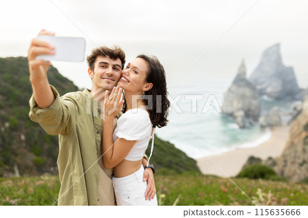 Happy loving couple embracing and taking selfie after engagement, celebrating unforgettable proposal, lady showing hand with ring, capturing moment on photo Happy loving couple embracing and taking selfie after engagement, celebrating unforgettable proposal, lady showing hand with ring, capturing moment on photo 115635666