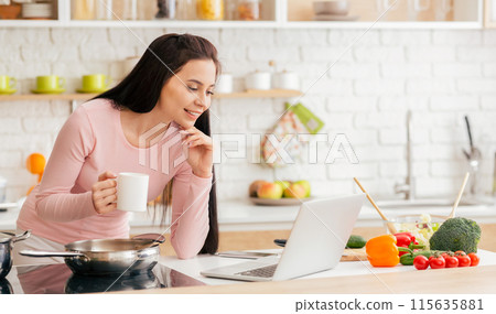 A woman is seated at a kitchen counter, engaged with a laptop screen in front of her. She appears focused and concentrated as she browses the internet or works on a project. A woman is seated at a kitchen counter, engaged with a laptop screen in front of her. She appears focused and concentrated as she browses the internet or works on a project. 115635881