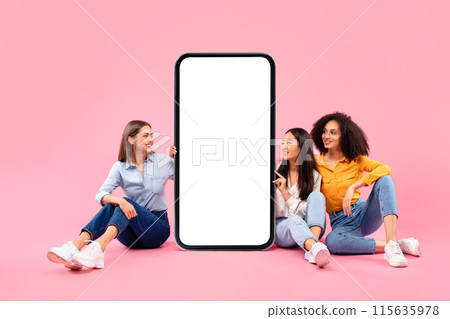 Check this offer. Happy diverse female friends sitting near huge smartphone with blank screen, demonstrating empty place for app and website design, copy space, collage, mockup 115635978