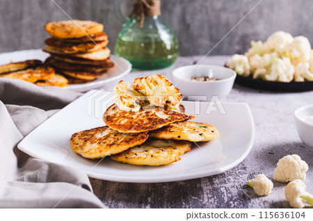 Spicy vegetarian cauliflower fritters on a plate on the table 115636104