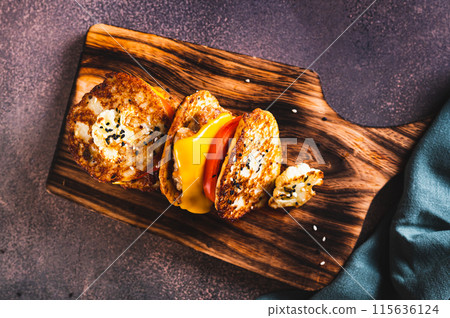 Close up of keto burgers on cauliflower fritters with cutlet, tomato and cheese on a board top view 115636124