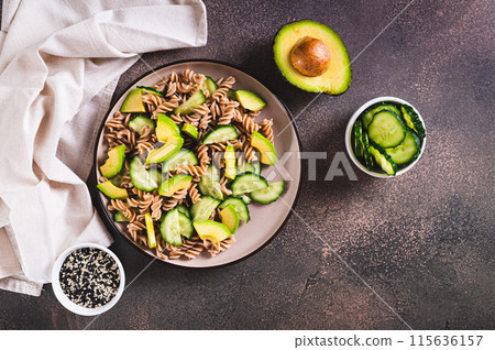 Delicious salad of buckwheat pasta, cucumber and avocado on a plate top view 115636157