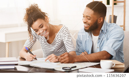 African-american couple planning honeymoon vacation with map, preparing for trip 115636207