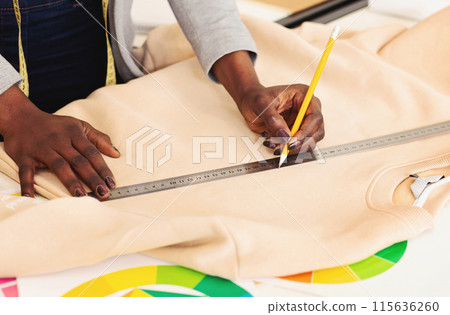A person is shown in the image measuring a piece of cloth using a ruler, focusing intently on accurately determining the length of the fabric, cropped A person is shown in the image measuring a piece of cloth using a ruler, focusing intently on accurately determining the length of the fabric, cropped 115636260