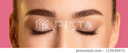 This image shows a close up of a woman eyelids, with defined eyebrows and subtle eye makeup. The photo is taken from a low angle, focusing on the upper eyelids and brow bones. 115636471