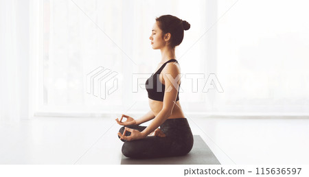 A woman wearing a black top is practicing yoga poses outdoors. She is focused and balanced, engaging in various stretches and movements to improve flexibility and strength, copy space 115636597