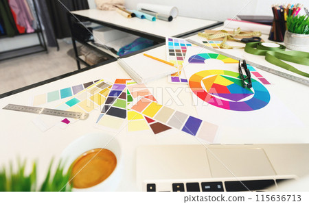 A vibrant and organized workspace is captured here, featuring an array of color swatches spread out alongside a color wheel, suggesting color scheme planning. Various design tools A vibrant and organized workspace is captured here, featuring an array of color swatches spread out alongside a color wheel, suggesting color scheme planning. Various design tools 115636713