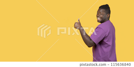 Great Choice. Positive young African American man gesturing thumbs up at camera over yellow background. Happy millennial guy recommending something with like. Panorama, copy space 115636840