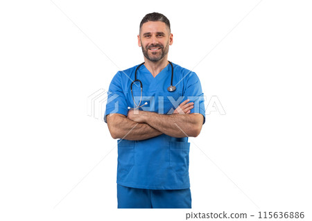 A man doctor in blue scrubs and a stethoscope around his neck stands with crossed arms in a professional pose. He exudes confidence and expertise in a medical setting. A man doctor in blue scrubs and a stethoscope around his neck stands with crossed arms in a professional pose. He exudes confidence and expertise in a medical setting. 115636886