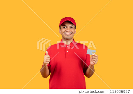 A cheerful delivery man dressed in a red uniform and cap gives a thumbs up while holding a card, standing against a bright yellow background. 115636937