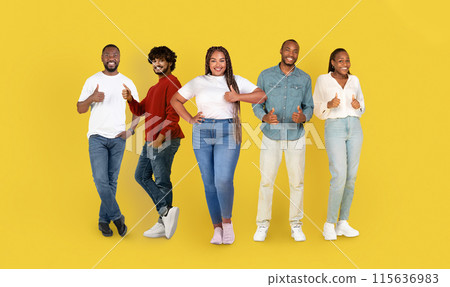 Smiling mature international people in casual, show thumbs up, enjoy spare time, isolated on yellow studio background, panorama. Recommendation work, approve, ad and offer 115636983