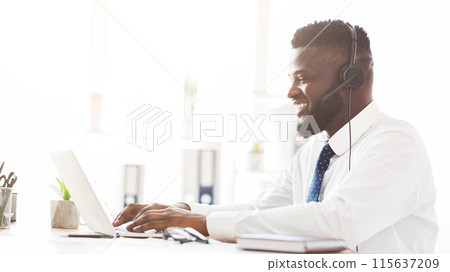 Young african american customer service agent working in office, side view, panorama with free space 115637209