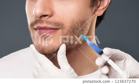 Beauty injection. Doctor filling lifting preparation into male face, panorama with free space 115637270