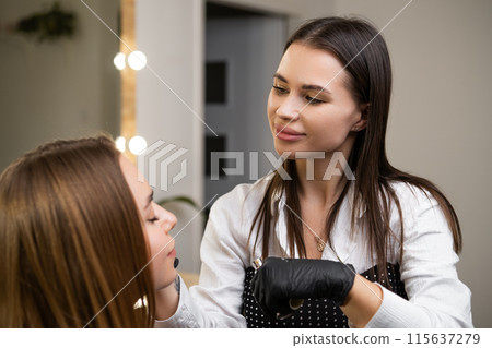 A woman receives a brow lamination treatment at a beauty salon 115637279