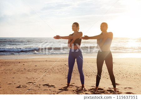 Cheerful pretty young caucasian women enjoy morning workout, sports, active lifestyle, doing hand stretching on sea beach. Vitality, energy, motivation and body care outdoor 115637351