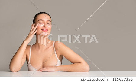 A woman in underwear is laying on a table with her hands covering her face. She appears to be deep in thought or possibly in distress, panorama with copy space A woman in underwear is laying on a table with her hands covering her face. She appears to be deep in thought or possibly in distress, panorama with copy space 115637356