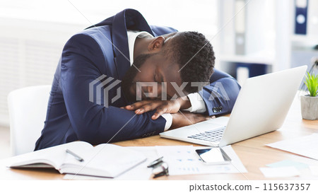 Tired african american young businessman sleeping in his office, overworking concept, panorama with copy space Tired african american young businessman sleeping in his office, overworking concept, panorama with copy space 115637357