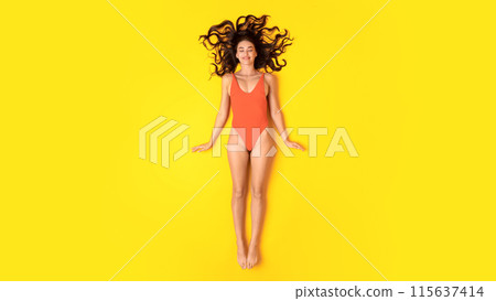Summer Haircare And Skincare. Lady Relaxing On Vacation Posing Wearing Orange One Piece Swimsuit Lying And Sunbathing Over Yellow Studio Background, View From Above. Panorama 115637414