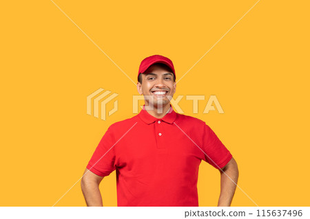 A cheerful man stands with his hands on his hips, wearing a bright red uniform and matching cap, against a vibrant yellow backdrop. He is smiling widely, appearing enthusiastic and approachable. A cheerful man stands with his hands on his hips, wearing a bright red uniform and matching cap, against a vibrant yellow backdrop. He is smiling widely, appearing enthusiastic and approachable. 115637496